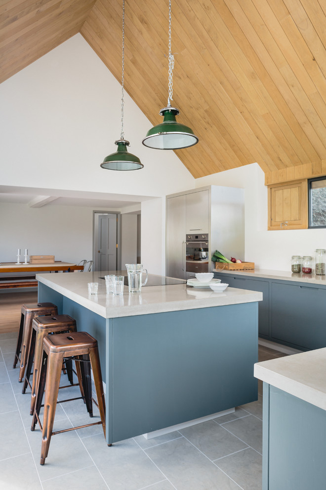 Inspiration for a large contemporary l-shaped kitchen/diner in Wiltshire with a double-bowl sink, flat-panel cabinets, grey cabinets, concrete worktops, stainless steel appliances and an island.