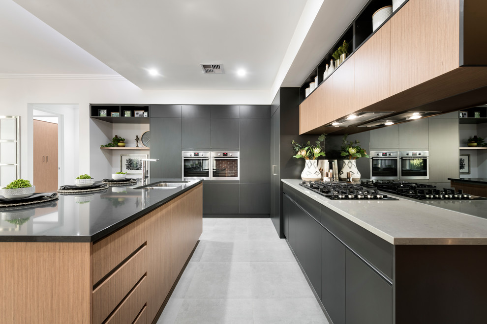 Design ideas for a medium sized contemporary l-shaped open plan kitchen in Perth with a submerged sink, flat-panel cabinets, black cabinets, metallic splashback, mirror splashback, an island, grey floors, grey worktops, composite countertops, stainless steel appliances and ceramic flooring.