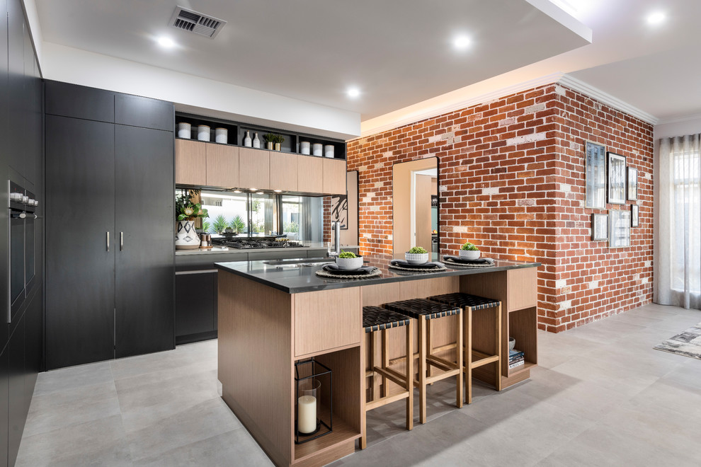 Inspiration for a mid-sized contemporary galley ceramic tile and gray floor open concept kitchen remodel in Perth with an undermount sink, flat-panel cabinets, black cabinets, solid surface countertops, metallic backsplash, mirror backsplash, stainless steel appliances, an island and gray countertops