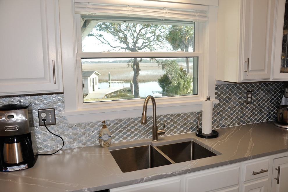Moderne Küche mit Unterbauwaschbecken, weißen Schränken, Quarzwerkstein-Arbeitsplatte, Küchenrückwand in Grau, Rückwand aus Glasfliesen, Kücheninsel und grauer Arbeitsplatte