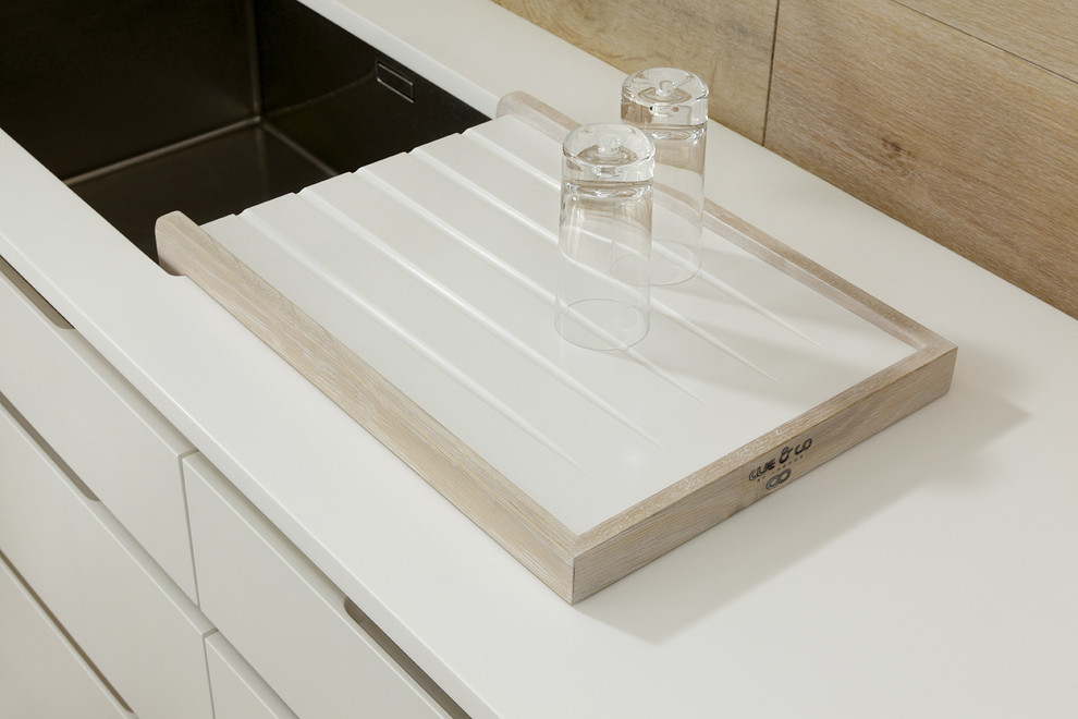 Foto di una cucina lineare nordica con ante lisce, ante bianche e top in superficie solida