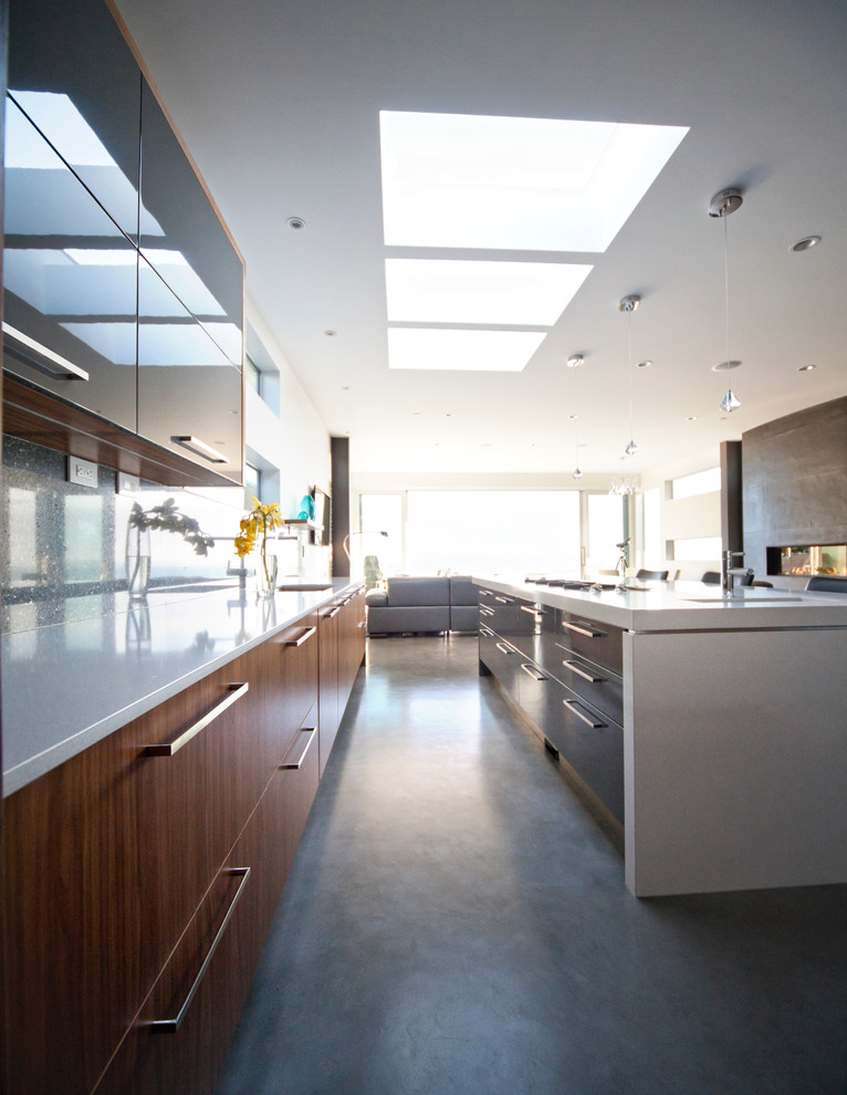 This is an example of a modern open plan kitchen in Vancouver with flat-panel cabinets and medium wood cabinets.