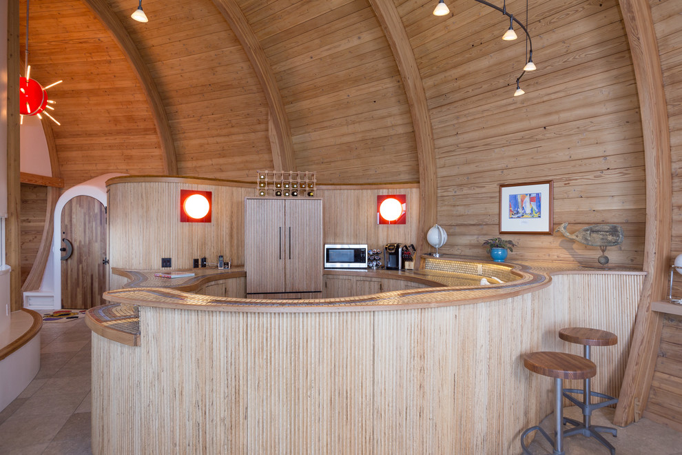 Immagine di una cucina stile marinaro con ante lisce, ante in legno chiaro, top in legno, elettrodomestici da incasso e penisola