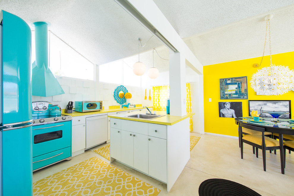 Inspiration for a mid-century modern beige floor eat-in kitchen remodel in San Diego with a drop-in sink, flat-panel cabinets, white cabinets, white backsplash, colored appliances, an island and yellow countertops