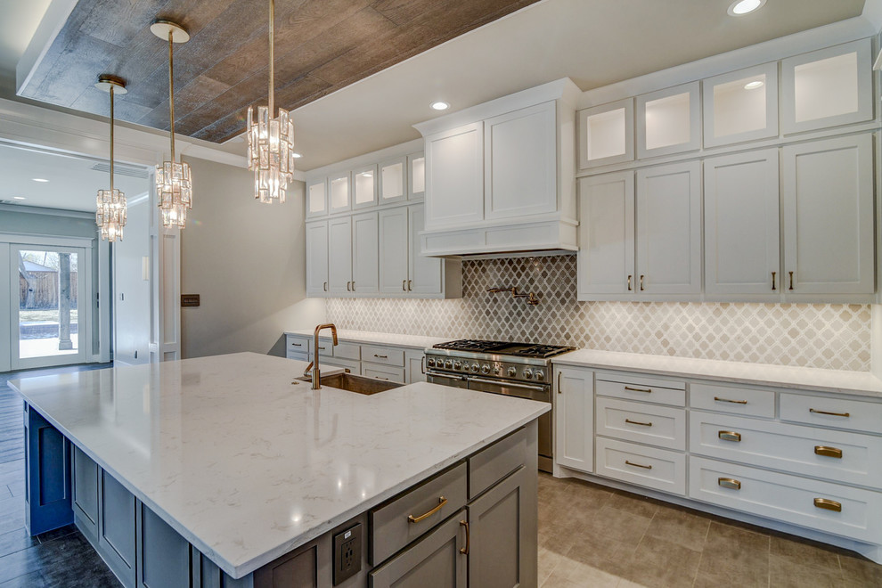 Inspiration for a large craftsman single-wall ceramic tile and brown floor eat-in kitchen remodel in Dallas with a farmhouse sink, beige backsplash, ceramic backsplash, stainless steel appliances, an island, white countertops, shaker cabinets, white cabinets and quartz countertops