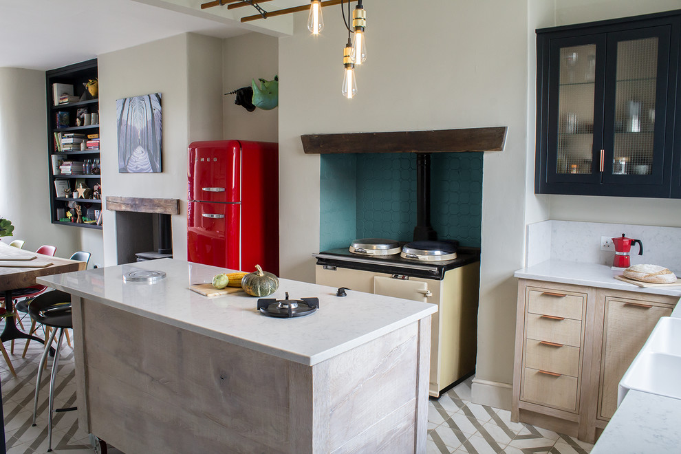 Immagine di una cucina boho chic di medie dimensioni con lavello stile country, ante lisce, ante in legno chiaro, top in superficie solida e elettrodomestici colorati