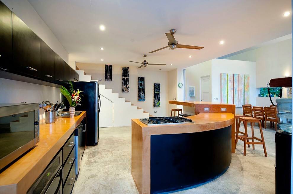 Esempio di una grande cucina stile marinaro con lavello a doppia vasca, ante nere, paraspruzzi bianco, elettrodomestici in acciaio inossidabile e pavimento in cemento