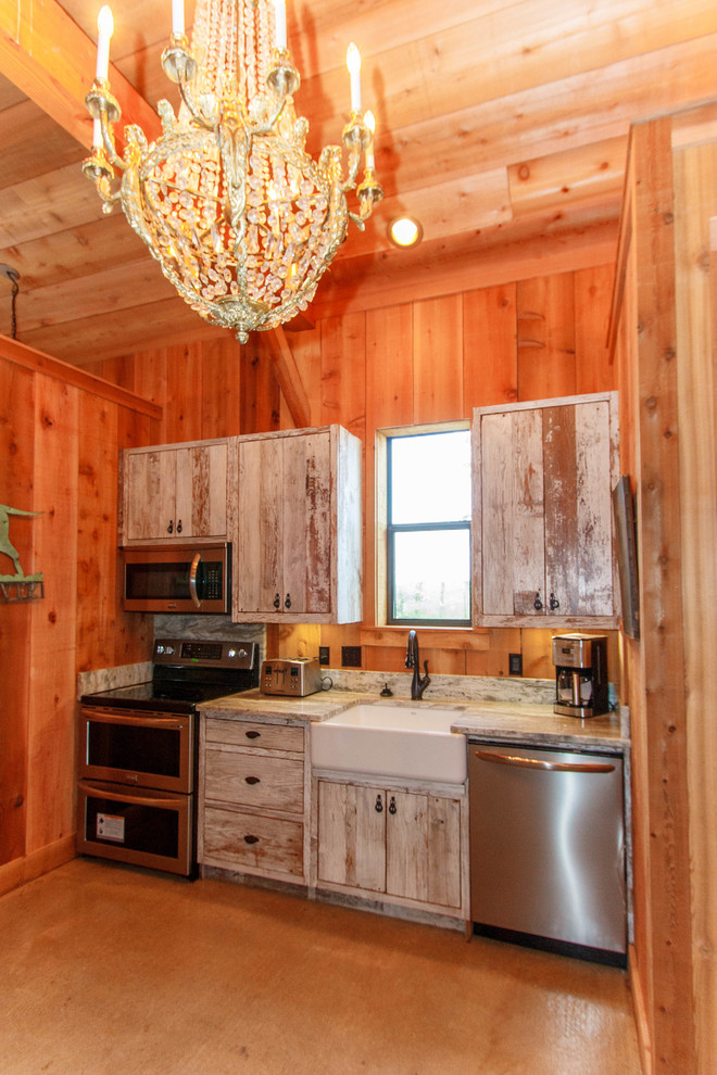 Exemple d'une petite cuisine américaine linéaire montagne en bois vieilli avec un évier de ferme, un placard à porte plane, un plan de travail en bois, un électroménager en acier inoxydable, sol en béton ciré et un sol marron.