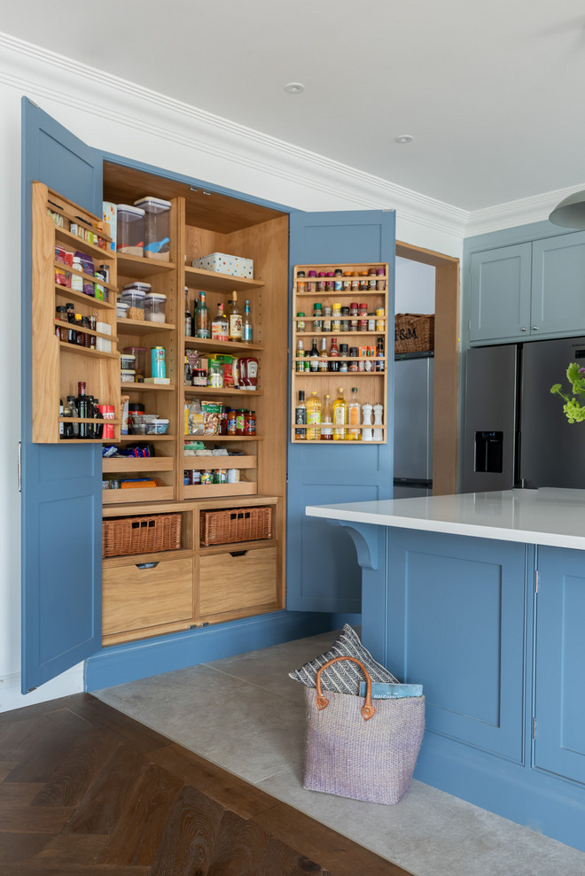 Große Maritime Küche mit Schrankfronten im Shaker-Stil, blauen Schränken, Quarzit-Arbeitsplatte, Küchengeräten aus Edelstahl, Keramikboden, Kücheninsel, weißer Arbeitsplatte und grauem Boden in Surrey