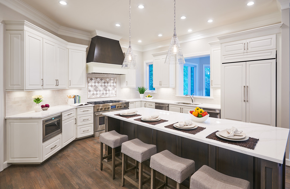 Kitchen - traditional u-shaped dark wood floor and brown floor kitchen idea in DC Metro with an undermount sink, raised-panel cabinets, white cabinets, multicolored backsplash, paneled appliances, an island and white countertops