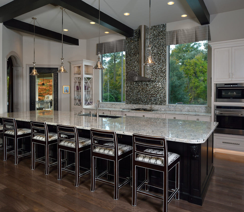 Inspiration for a huge transitional u-shaped light wood floor open concept kitchen remodel in Houston with a drop-in sink, recessed-panel cabinets, white cabinets, metallic backsplash, stainless steel appliances, an island, glass sheet backsplash and granite countertops