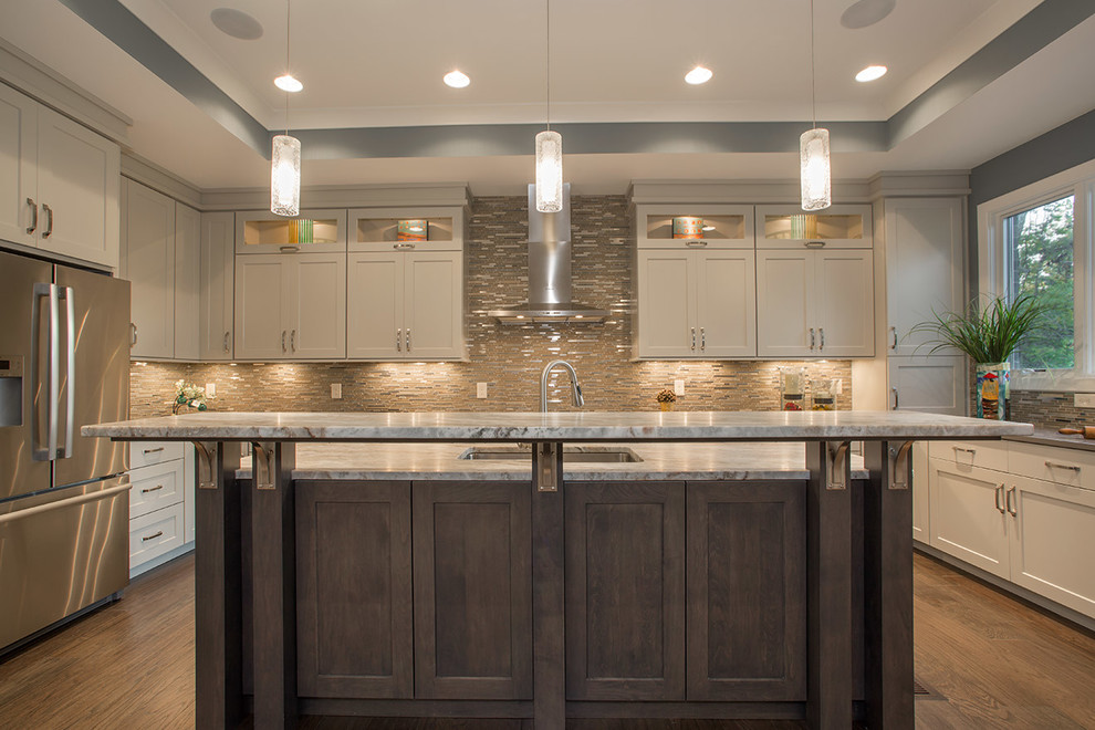 Inspiration for a mid-sized modern u-shaped medium tone wood floor eat-in kitchen remodel in Cincinnati with a drop-in sink, glass-front cabinets, gray cabinets, granite countertops, beige backsplash, ceramic backsplash, stainless steel appliances and an island
