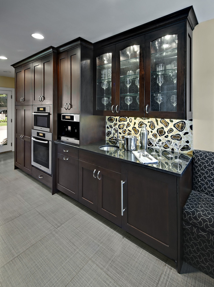 Modelo de cocina comedor contemporánea de tamaño medio con armarios con paneles empotrados, puertas de armario de madera en tonos medios, salpicadero blanco y electrodomésticos con paneles