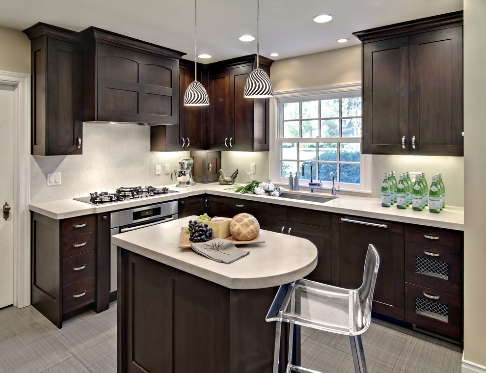 Mittelgroße Moderne Küche in L-Form mit dunklen Holzschränken, Schrankfronten mit vertiefter Füllung, Küchenrückwand in Weiß und Elektrogeräten mit Frontblende in Minneapolis