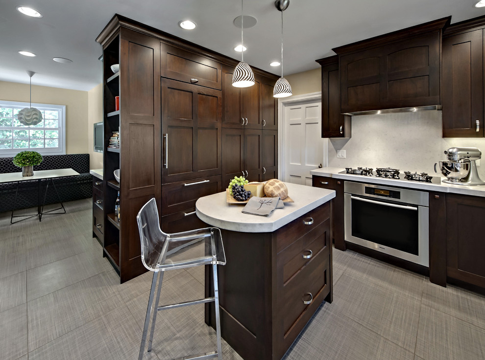 Cette image montre une cuisine américaine encastrable design en bois foncé de taille moyenne avec un placard avec porte à panneau encastré et une crédence blanche.