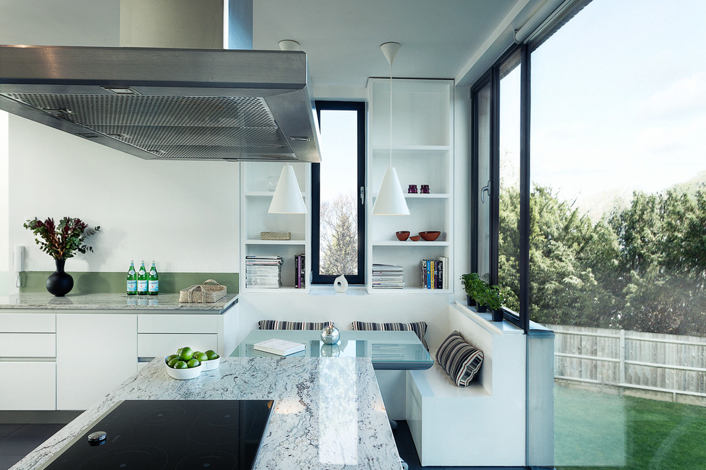 Foto di una cucina abitabile design con ante lisce e ante bianche