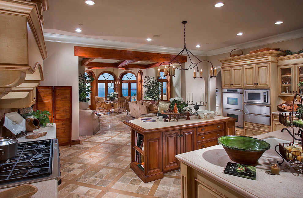 Inspiration for a mediterranean open plan kitchen in Orange County with beige cabinets, granite worktops, stainless steel appliances and multiple islands.