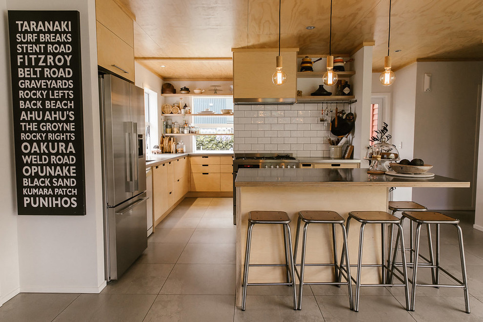 Idéer för att renovera ett funkis grå grått kök med öppen planlösning, med släta luckor, skåp i ljust trä, vitt stänkskydd, stänkskydd i keramik, rostfria vitvaror, en köksö och grått golv