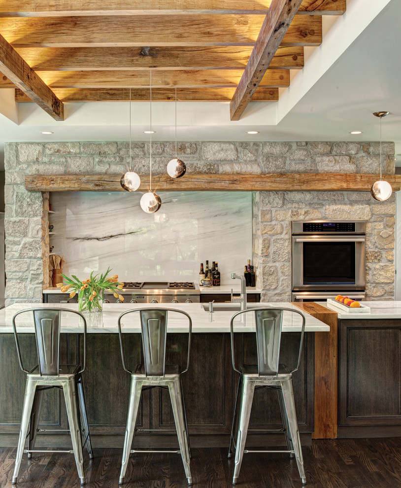 Foto di una cucina stile rurale di medie dimensioni con lavello sottopiano, ante in legno bruno, top in marmo, elettrodomestici in acciaio inossidabile, parquet scuro e paraspruzzi in marmo