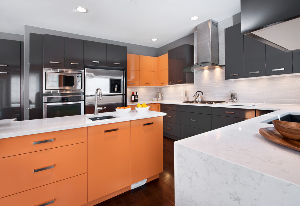 Modelo de cocina minimalista con fregadero bajoencimera, armarios con paneles lisos, puertas de armario naranjas, salpicadero blanco, electrodomésticos de acero inoxidable y una isla