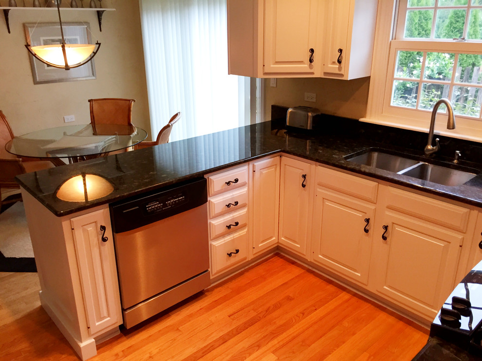 Example of a large classic u-shaped medium tone wood floor eat-in kitchen design in Chicago with raised-panel cabinets and white cabinets