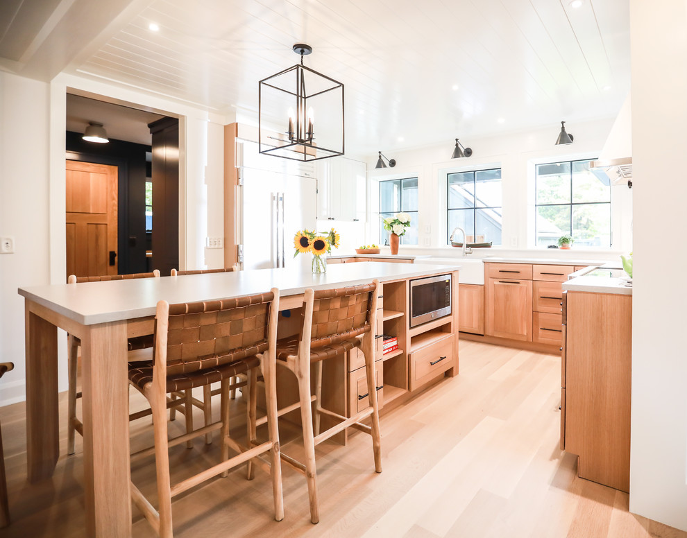 プロビデンスにあるカントリー風のおしゃれなキッチン (エプロンフロントシンク、中間色木目調キャビネット、シルバーの調理設備、ベージュの床、白いキッチンカウンター、淡色無垢フローリング) の写真
