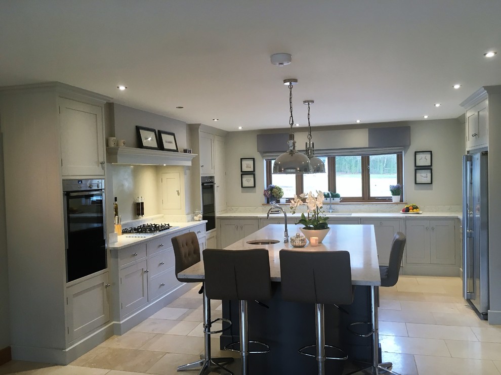 Example of a huge transitional u-shaped open concept kitchen design in Essex with recessed-panel cabinets and an island