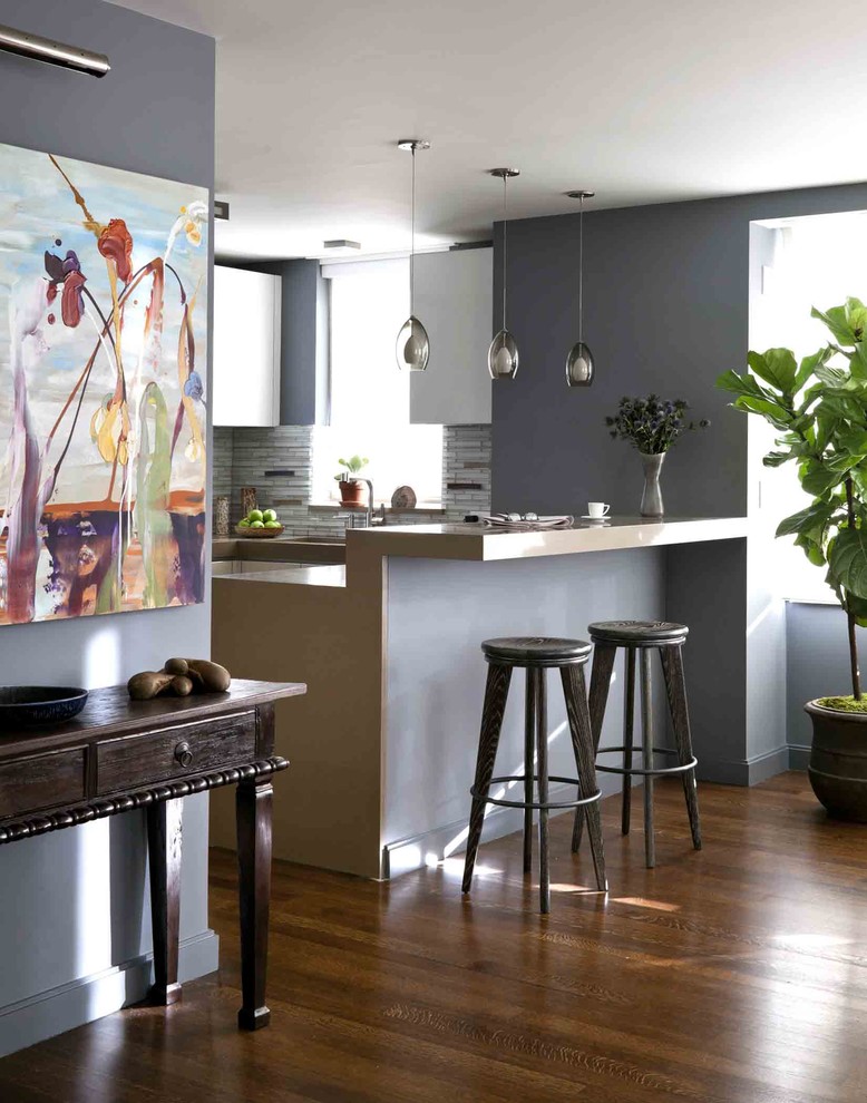 Moderne Küche mit flächenbündigen Schrankfronten, weißen Schränken und Küchenrückwand in Grau in New York