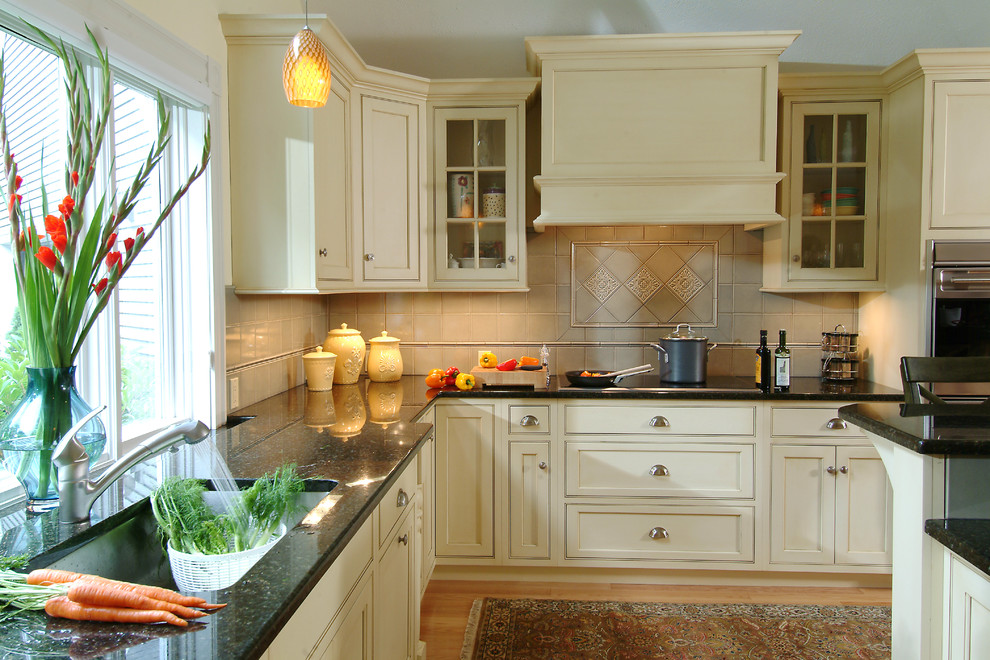 Klassische Küche mit Granit-Arbeitsplatte, Waschbecken, Schrankfronten mit vertiefter Füllung, beigen Schränken, Küchenrückwand in Beige und schwarzer Arbeitsplatte in Boston