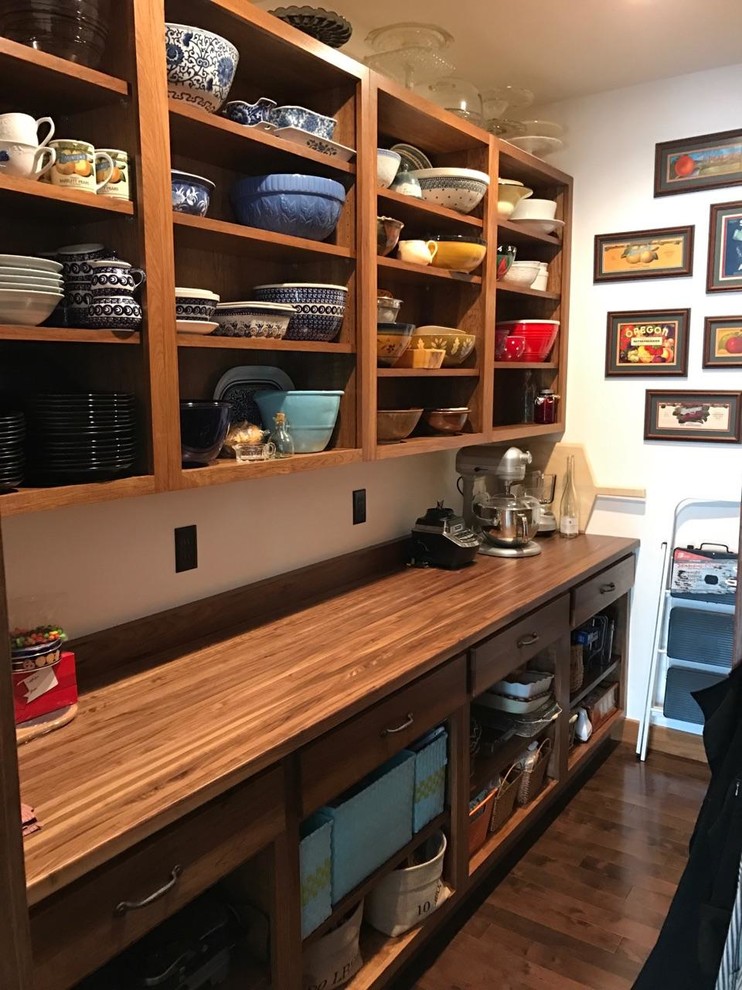 Inspiration for a mid-sized timeless galley laminate floor and brown floor kitchen pantry remodel in Minneapolis with shaker cabinets, medium tone wood cabinets, wood countertops, stainless steel appliances and an island