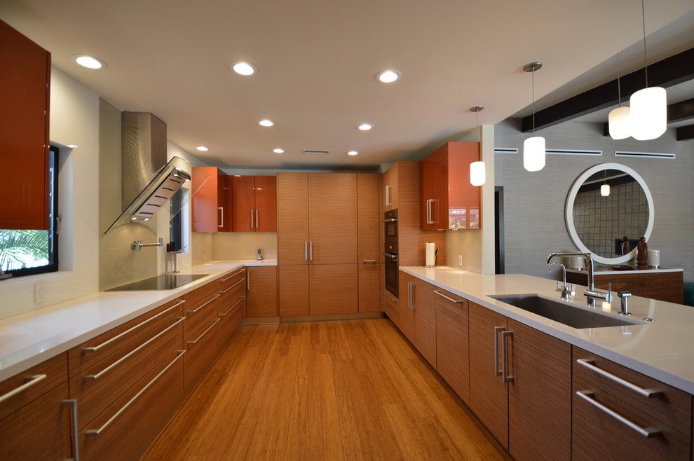 Bild på ett stort funkis kök med öppen planlösning, med en undermonterad diskho, släta luckor, skåp i mellenmörkt trä, marmorbänkskiva, rostfria vitvaror och mellanmörkt trägolv