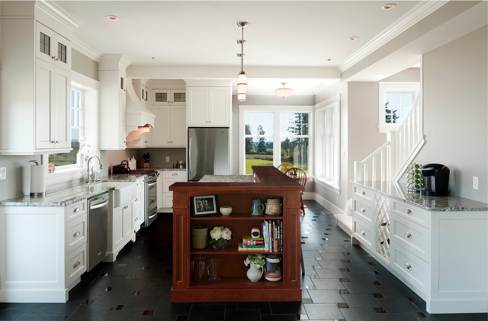 Foto på ett lantligt l-kök, med rostfria vitvaror, en rustik diskho, skåp i shakerstil, vita skåp och svart golv
