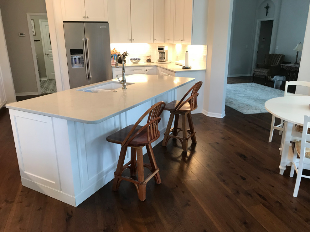 Inspiration for a large modern u-shaped dark wood floor and brown floor eat-in kitchen remodel in Jacksonville with an undermount sink, shaker cabinets, white cabinets, quartzite countertops, white backsplash, glass tile backsplash, stainless steel appliances, an island and gray countertops