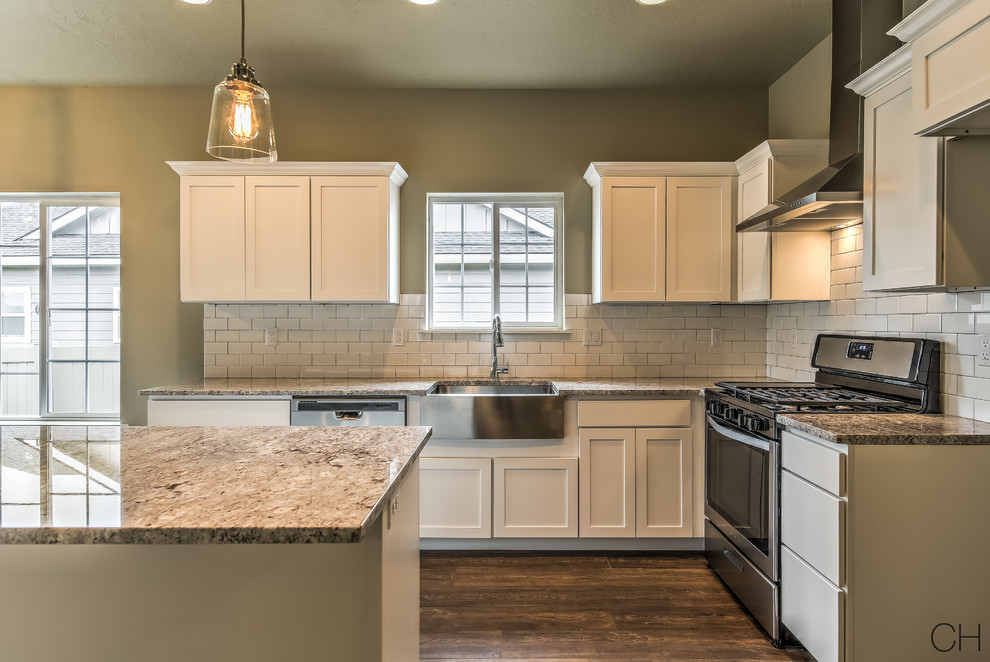 Eat-in kitchen - small craftsman l-shaped eat-in kitchen idea in Boise with a farmhouse sink, shaker cabinets, white cabinets, granite countertops, white backsplash, subway tile backsplash, stainless steel appliances and an island