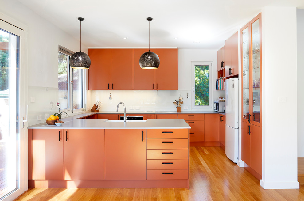 Idée de décoration pour une cuisine design avec un sol en bois brun.
