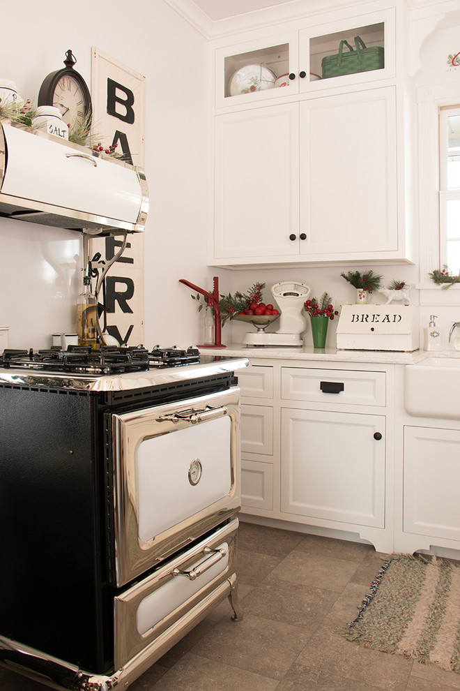 Modelo de cocina campestre pequeña con fregadero sobremueble, armarios estilo shaker, puertas de armario blancas, encimera de mármol y suelo de ladrillo