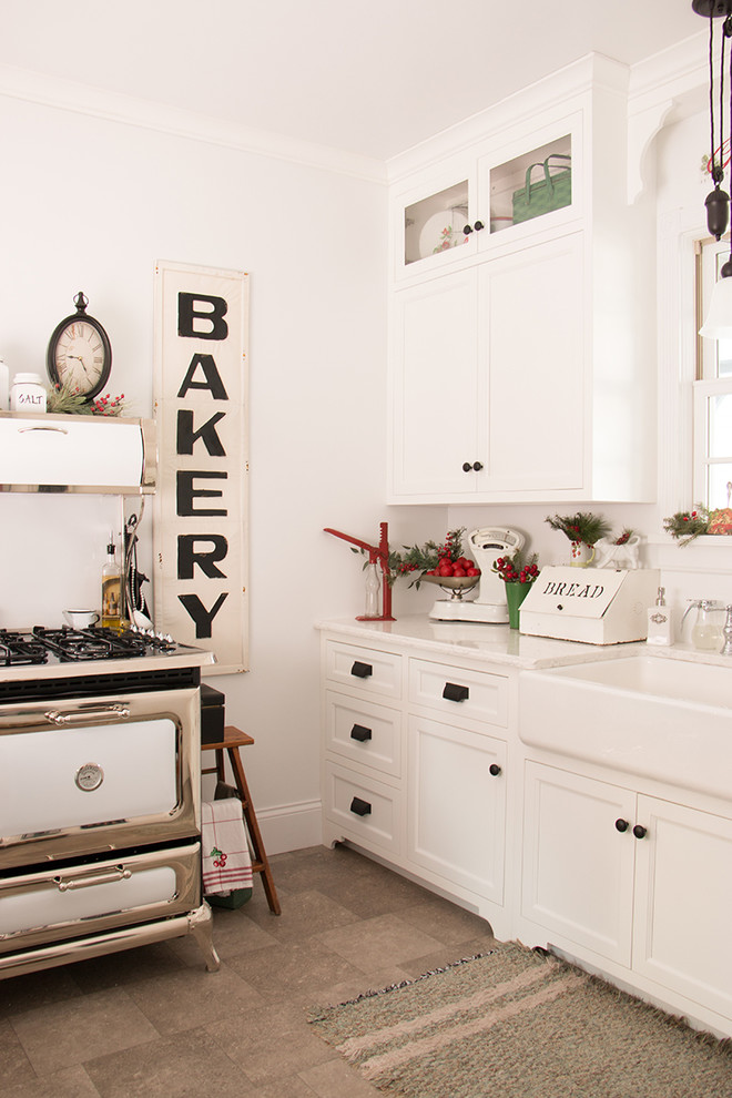Aménagement d'une petite cuisine parallèle campagne avec un évier de ferme, des portes de placard blanches, un placard à porte shaker et plan de travail en marbre.