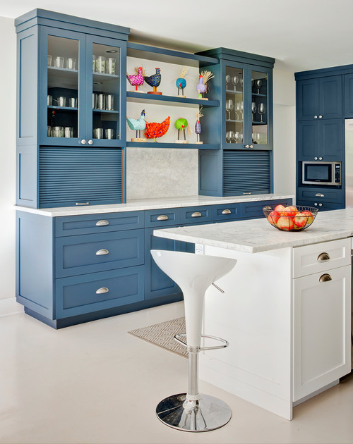Modern kitchen with navy blue cabinets, white island, and colorful decorative accents