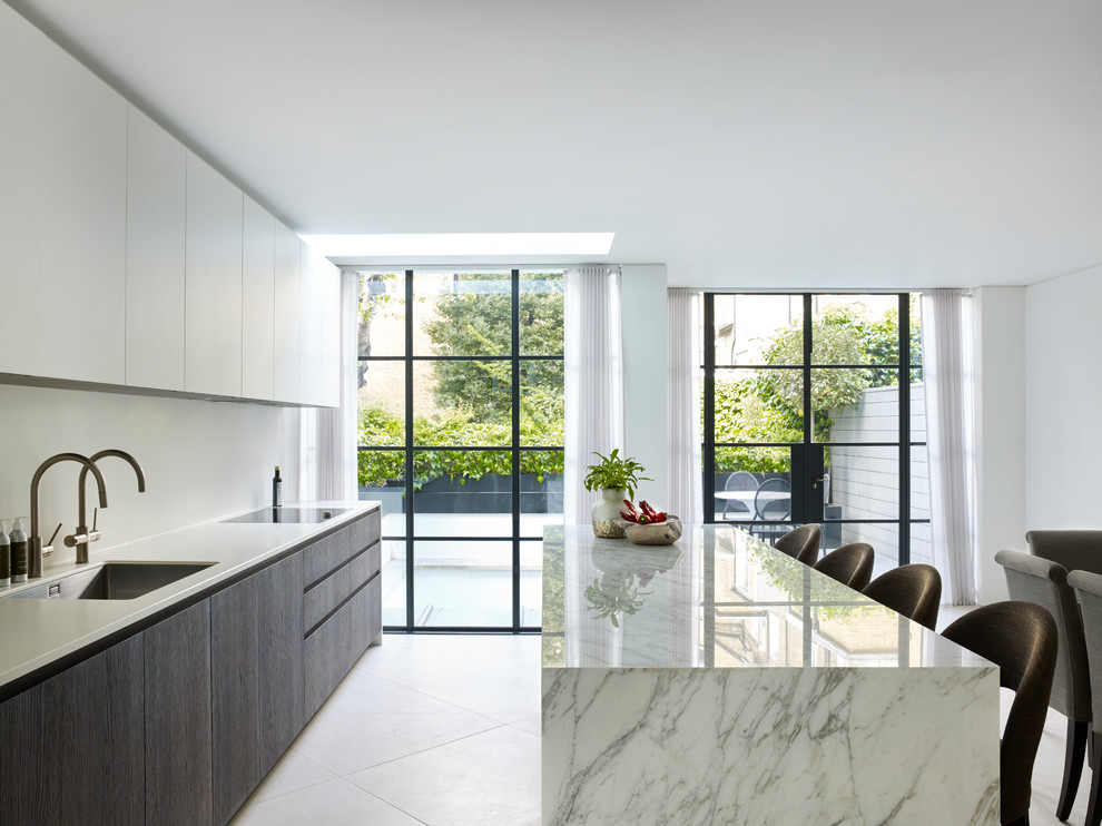 Foto di una cucina design con lavello sottopiano, ante in legno bruno, pavimento grigio e top bianco