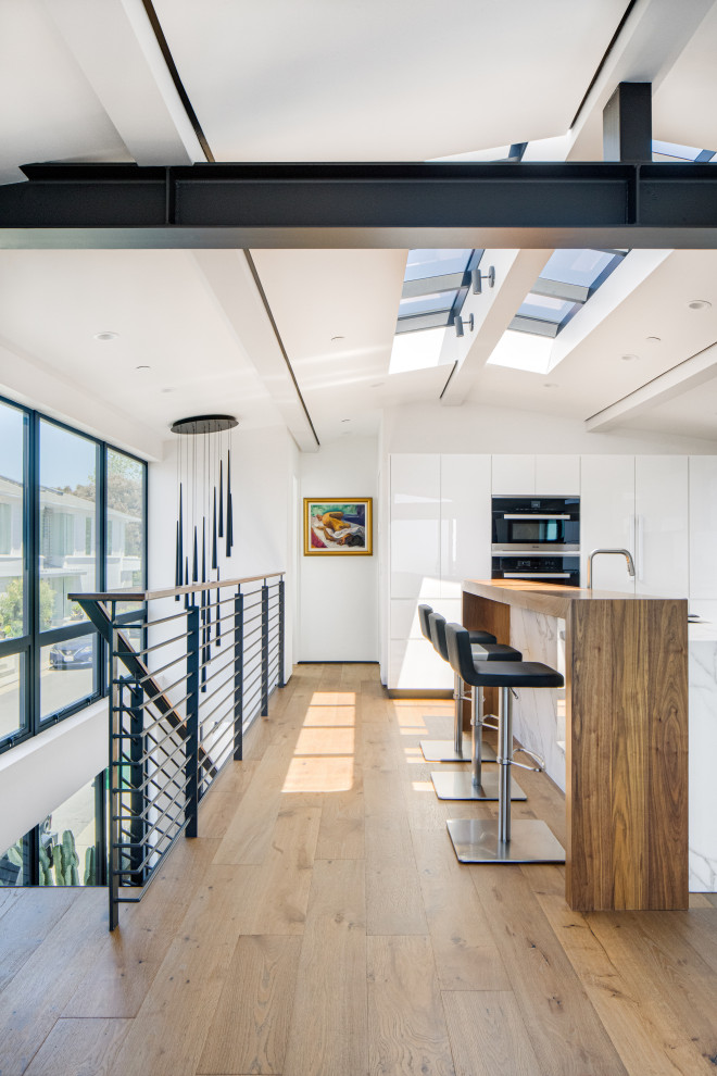 Esempio di una cucina moderna di medie dimensioni con lavello sottopiano, ante lisce, ante bianche, top in legno, paraspruzzi bianco, parquet chiaro, pavimento beige e top marrone