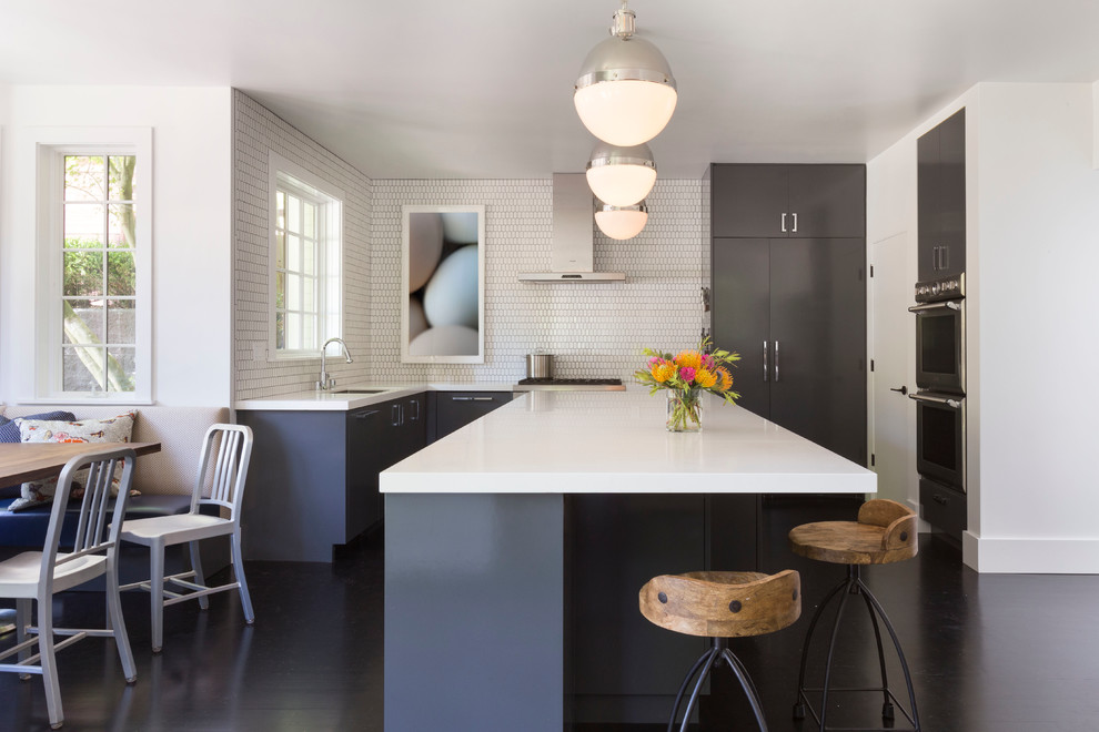 Eat-in kitchen - large contemporary u-shaped dark wood floor eat-in kitchen idea in San Francisco with white backsplash, an island, an undermount sink, flat-panel cabinets, gray cabinets and stainless steel appliances