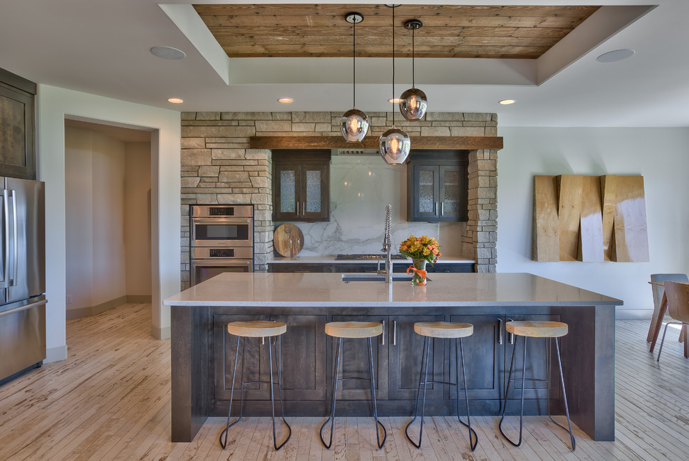 Eat-in kitchen - mid-sized transitional u-shaped eat-in kitchen idea in Omaha with a single-bowl sink, recessed-panel cabinets, dark wood cabinets, white backsplash, stainless steel appliances, an island and stone slab backsplash