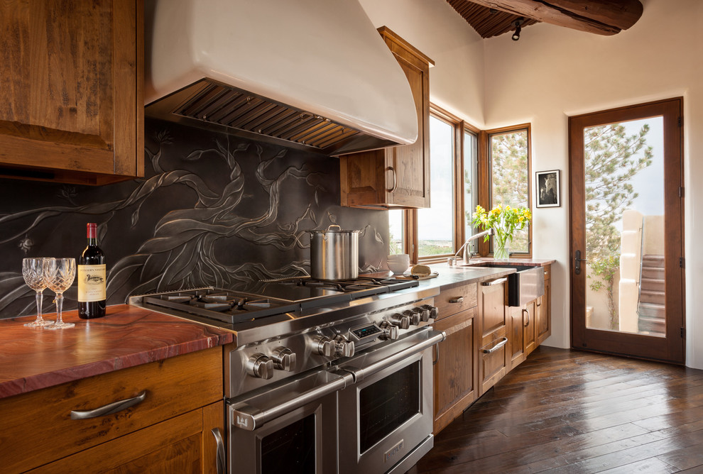 Ejemplo de cocina lineal de estilo americano con fregadero sobremueble, puertas de armario de madera oscura, electrodomésticos de acero inoxidable y suelo de madera en tonos medios
