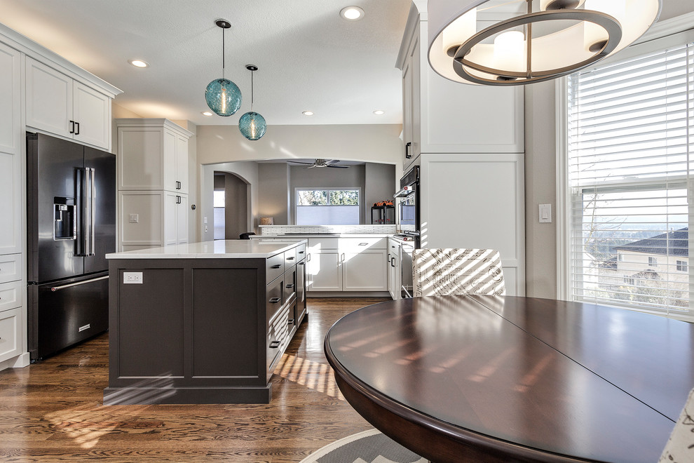 Example of a mid-sized minimalist u-shaped dark wood floor and brown floor eat-in kitchen design in Portland with an undermount sink, shaker cabinets, gray cabinets, quartzite countertops, white backsplash, mosaic tile backsplash, black appliances and an island