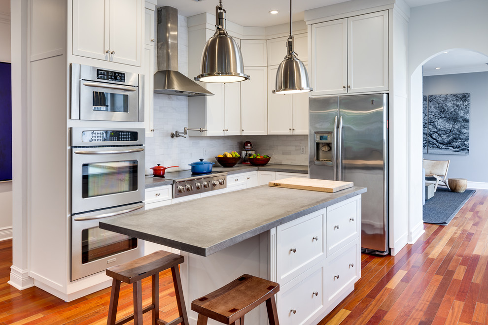 Foto di una cucina classica con ante in stile shaker, ante bianche, paraspruzzi grigio, elettrodomestici in acciaio inossidabile, pavimento in legno massello medio e pavimento marrone