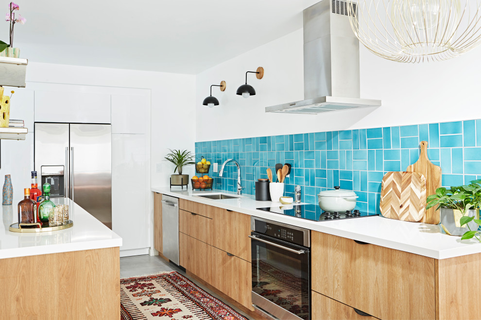 Medium sized bohemian l-shaped kitchen in Los Angeles with light wood cabinets, blue splashback, ceramic splashback, grey floors, white worktops, a submerged sink, flat-panel cabinets, stainless steel appliances and an island.