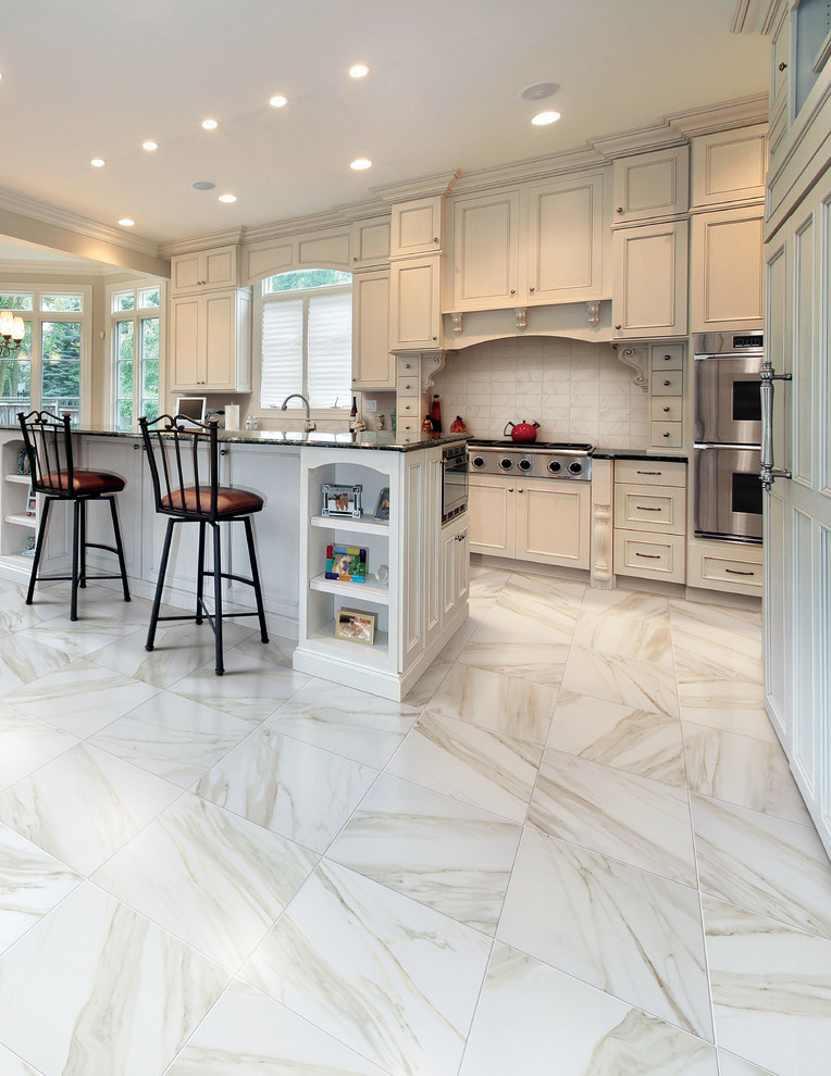 Large elegant l-shaped marble floor and white floor open concept kitchen photo in San Diego with an undermount sink, beaded inset cabinets, white cabinets, granite countertops, white backsplash, marble backsplash, paneled appliances and an island
