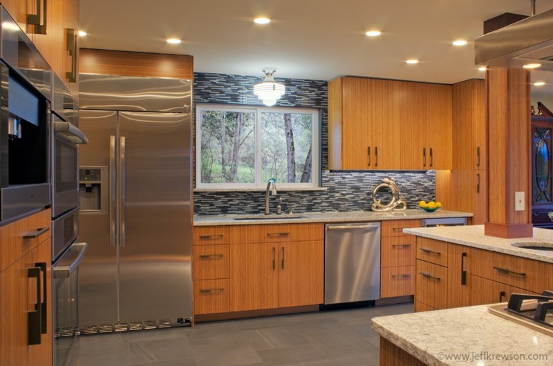Example of a transitional porcelain tile kitchen design in Seattle with medium tone wood cabinets, black backsplash and an island