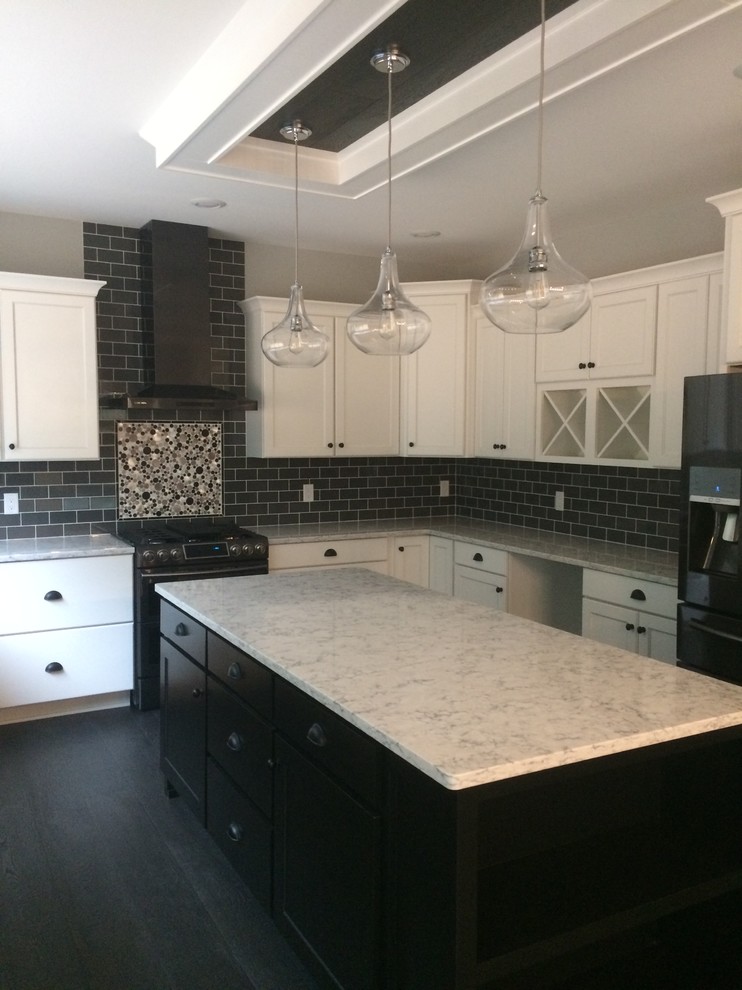 Exempel på ett stort kök, med släta luckor, vita skåp, bänkskiva i kvarts, svart stänkskydd, stänkskydd i stenkakel, svarta vitvaror, mörkt trägolv, en köksö och svart golv