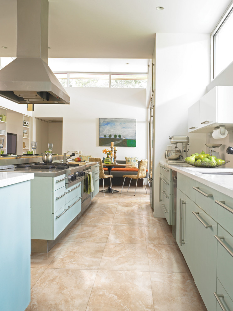 Example of a mid-sized transitional galley porcelain tile and beige floor eat-in kitchen design in Birmingham with an undermount sink, flat-panel cabinets, quartz countertops, stainless steel appliances, an island, blue cabinets, white backsplash and subway tile backsplash